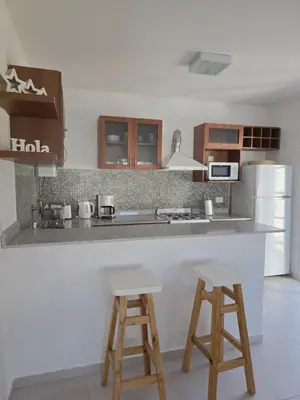 a kitchen with two bar stools and a counter top at Posta Espinillos 12 in Villa General Belgrano
