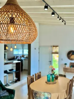 a dining room with a table with chairs and a lamp at Casa en Estancia Vieja a 5 min del centro de Carlos Paz in Villa Carlos Paz