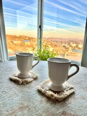 two cups sitting on a table in front of a window at Casa en Estancia Vieja a 5 min del centro de Carlos Paz in Villa Carlos Paz