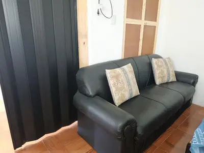 a black leather couch with two pillows on it at La Morada de sus Sueños Caeiro in Bialet Massé