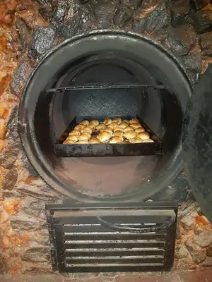 a stone oven with a tray of food in it at La Morada de sus Sueños Caeiro in Bialet Massé