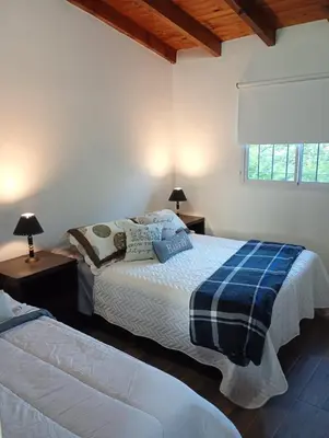 a bedroom with two beds and a window at Balcones del Rio in Santa Rosa de Calamuchita