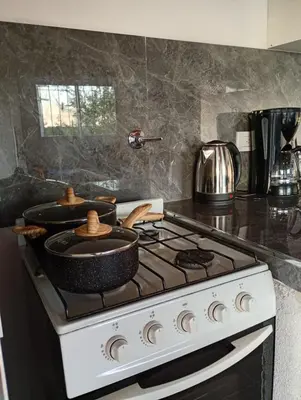 a kitchen stove with two pots and pans on it at Balcones del Rio in Santa Rosa de Calamuchita