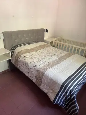 a bed in a room with a bedskirtspectspectssenalsenalsenalsenalsenal at Cabañas De La Colina in Villa General Belgrano