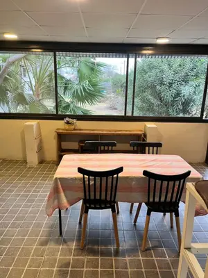 a dining room with a table and chairs and windows at Casa alquiler temporario, Cerro, Córdoba in Cordoba