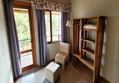 a room with a bunk bed and a chair and a window at Aldea de los Cerros in Villa Yacanto