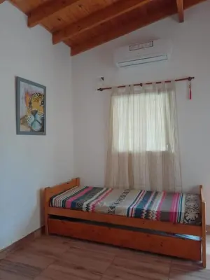 a bedroom with a wooden bed with a window at Casa Miranda in Merlo