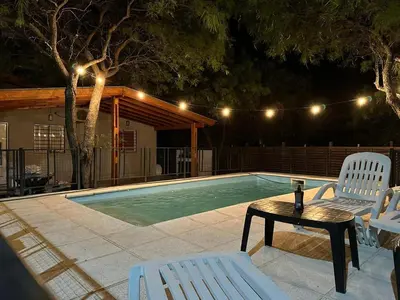 a swimming pool with two chairs and a table and a tablektop at Casa Miranda in Merlo