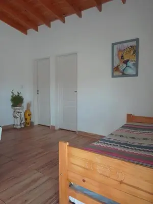 a bedroom with a bed and a wooden floor at Casa Miranda in Merlo
