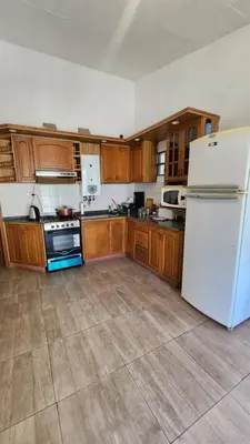 a kitchen with a white refrigerator and wooden cabinets at El Descanso Placentero 3 Habitaciones in Cordoba