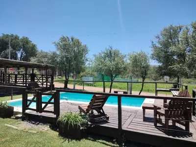 a deck with chairs next to a swimming pool at Bella Vista in Bialet Massé