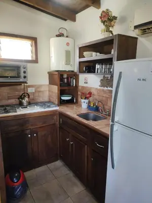 a kitchen with wooden cabinets and a white refrigerator at Bella Vista in Bialet Massé