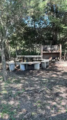 a picnic table and a bench in a park at Casita de los recuerdos in Villa Carlos Paz