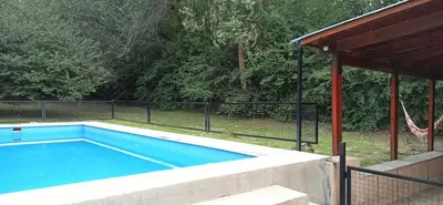 a swimming pool in a yard with a fence at Casita de los recuerdos in Villa Carlos Paz