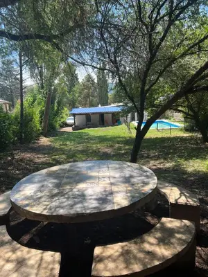 a picnic table in a park with a tree at Casita de los recuerdos in Villa Carlos Paz