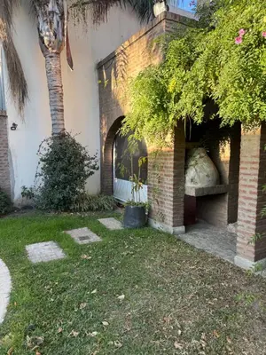 a house with a brick fireplace in a yard at Gravensteen Urca in Cordoba