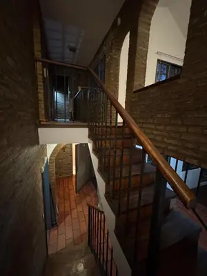 a spiral staircase in a building with a brick wall at Gravensteen Urca in Cordoba