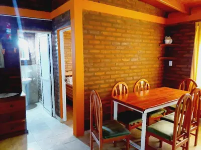a dining room with a wooden table and chairs at Cabañas Yarel in Alpa Corral