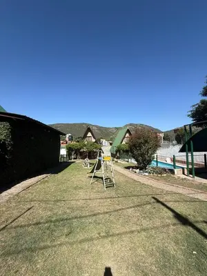 a yard with a ladder on the grass at Cabañas Pindahue - Alojamiento Huilen in Villa Carlos Paz