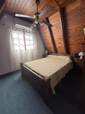 a bedroom with a bed and a ceiling fan at Cabañas Pindahue - Alojamiento Huilen in Villa Carlos Paz