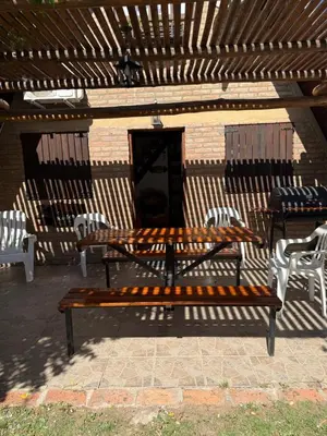 a wooden bench sitting in front of a building at Cabañas Pindahue - Alojamiento Huilen in Villa Carlos Paz