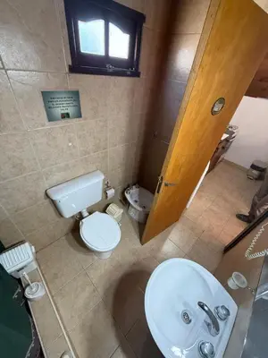 a bathroom with a white toilet and a sink at Cabañas Pindahue - Alojamiento Huilen in Villa Carlos Paz