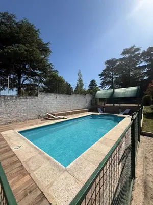 a swimming pool with a fence around it at Cabañas Pindahue - Alojamiento Huilen in Villa Carlos Paz
