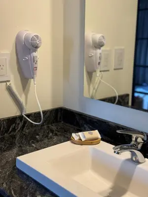 a bathroom sink with a hair dryer and a mirror at Agua de Tajamar in Alta Gracia