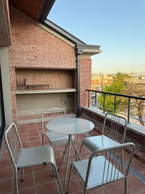 a patio with two tables and chairs on a balcony at Agua de Tajamar in Alta Gracia