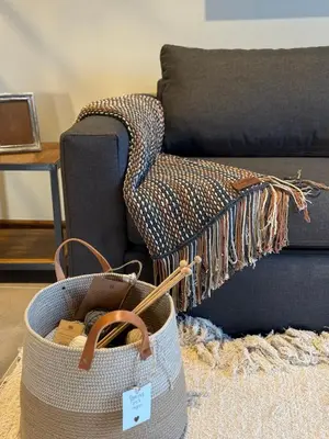 a basket on the floor in front of a couch at Agua de Tajamar in Alta Gracia