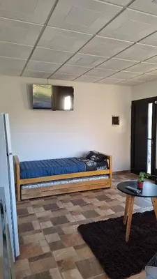 a bed sitting in a room with a table at Napoles complejo in Villa de Las Rosas
