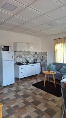 a kitchen and living room with a couch and a table at Napoles complejo in Villa de Las Rosas