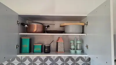 a kitchen shelf with cooking utensils and other kitchen items at Napoles complejo in Villa de Las Rosas