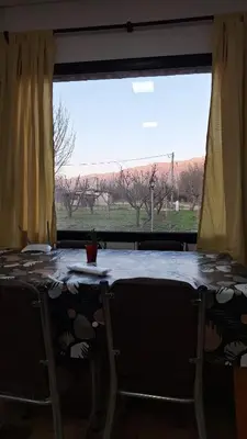 a table with a view of a field from a window at Napoles complejo in Villa de Las Rosas
