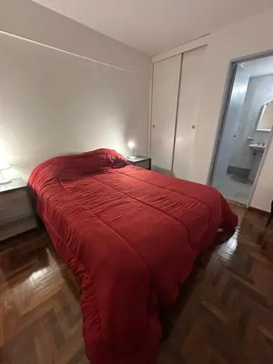 a bedroom with a bed with a red blanket at Mandala Apart in Cordoba