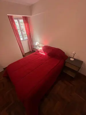 a bedroom with a red bed and a window at Mandala Apart in Cordoba