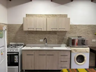a kitchen with a sink and a washing machine at Dos Osos in Villa General Belgrano