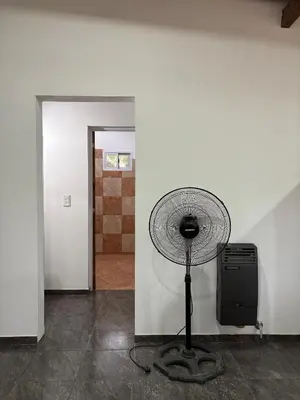 a fan sitting in the corner of a room at Dos Osos in Villa General Belgrano