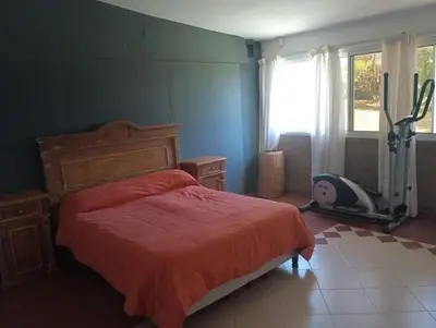 a bedroom with a bed with a red comforter at Los Algarrobos in Bialet Massé