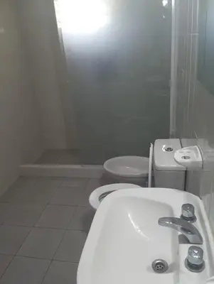 a white bathroom with a toilet and a sink at Los Algarrobos in Bialet Massé