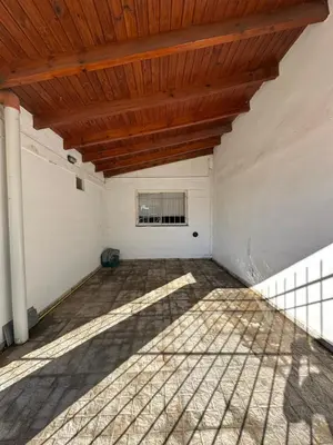 an empty garage with a wooden ceiling and a window at Sierra Chica in Alta Gracia
