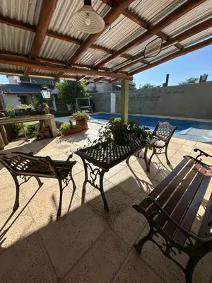 a patio with three chairs and a table and a bench at Sierra Chica in Alta Gracia