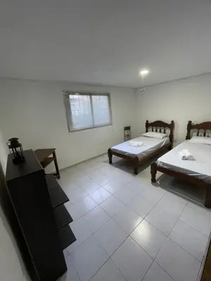 a room with two beds and a tv in it at Sierra Chica in Alta Gracia