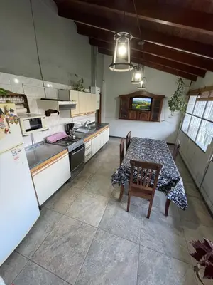 a kitchen with a table with chairs and a refrigerator at Sierra Chica in Alta Gracia