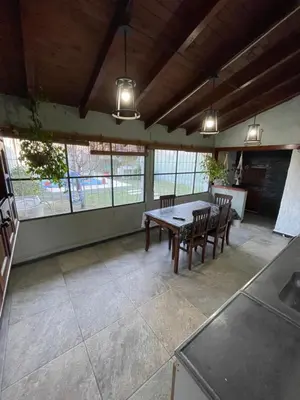 a dining room with a table and chairs and windows at Sierra Chica in Alta Gracia