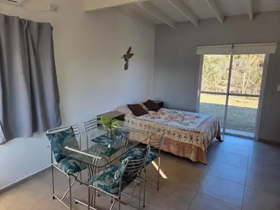 a bedroom with a bed and a glass table and chairs at La Jocunda - Cortaderas - Piscu Yaco in Cortaderas