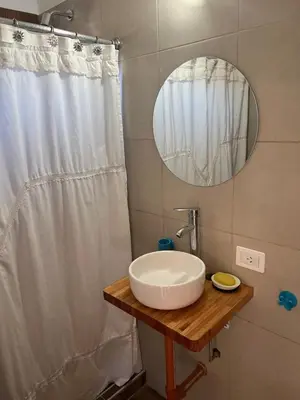 a bathroom with a white sink and a mirror at La Jocunda - Cortaderas - Piscu Yaco in Cortaderas