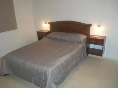 a bedroom with a bed and two night stands at Lomas de Belgrano in Villa General Belgrano