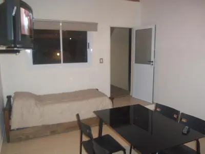 a bedroom with a bed and a table and a window at Lomas de Belgrano in Villa General Belgrano