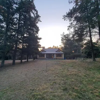 a house in the middle of a field with trees at El Cartucho in Villa General Belgrano